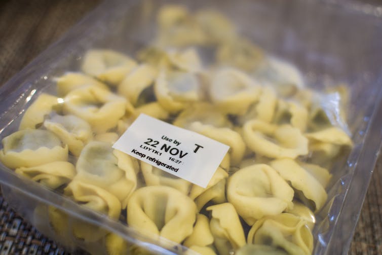 A plastic bag of precooked, stuffed pasta lies with its label face up, reading 'Use by 22 November' and 'keep refrigerated.'