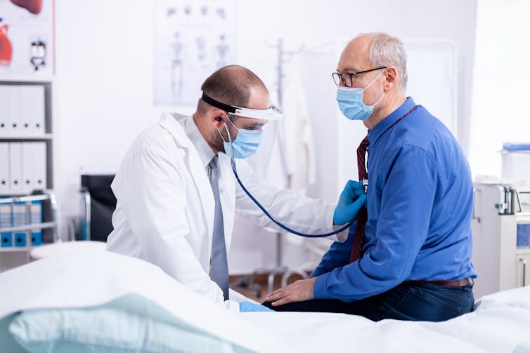 A senior man is examined by a doctor.