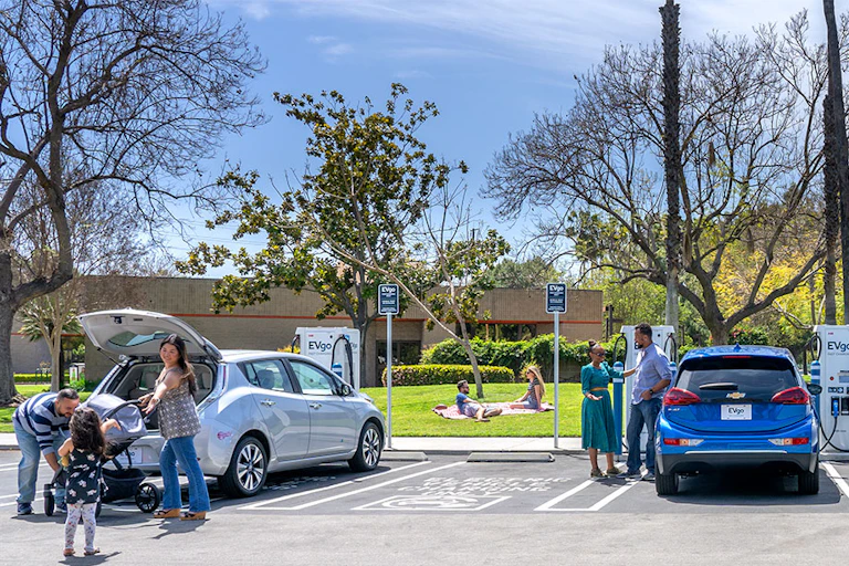 A row of EV cars in a parking lot charging.