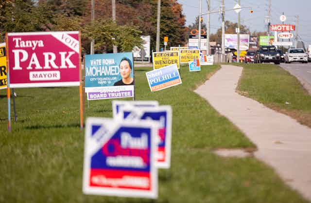 Election signs line a busy road.