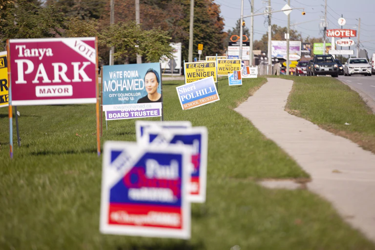 Election signs line a busy road.