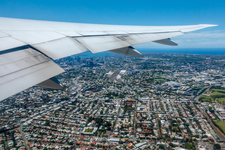 view out of aeroplane window looking down at city below