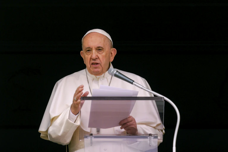 The Pope stands at a mic
