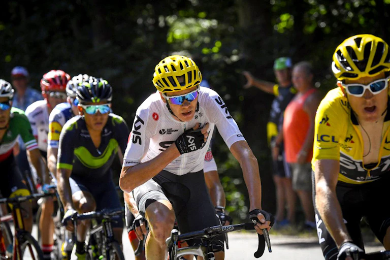 Cyclistes en montée dont l'un se tient la poitrine