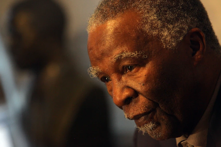 A greying man looks down in a pensive mood.