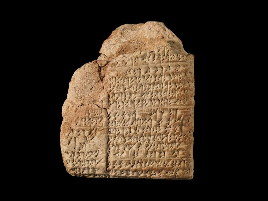 A clay tablet with writing on it against a black background.