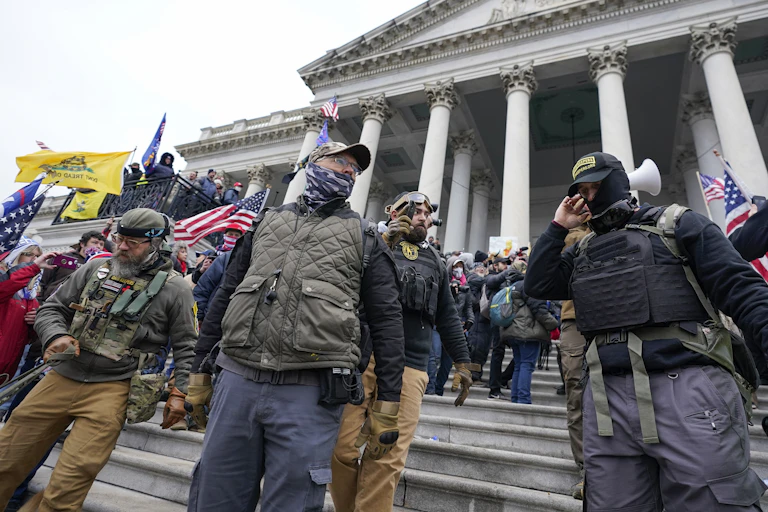 Members of the Oath Keepers, clad in military clothing, stand outside the U.S. Capitol