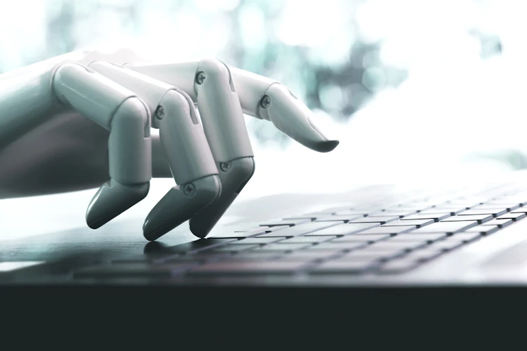 a robot hand hovers over a keyboard