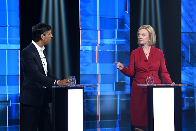 RIshi Sunak y Liz Truss debatiendo en los podios.