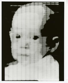 Face of a baby in a black and white image.