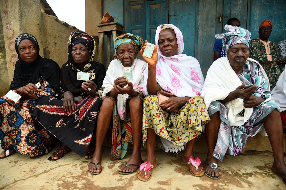 Elderly women sit holding their voter's cards at a polling booth during the gubernatorial election at Ede in Osun State, southwest Nigeria, on 16 July, 2022.