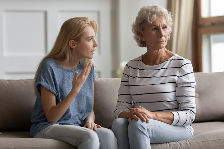 A young woman looks to be arguing with an older woman who is looking away from her.