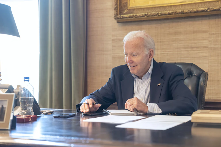 President Joe Biden sitting a desk.