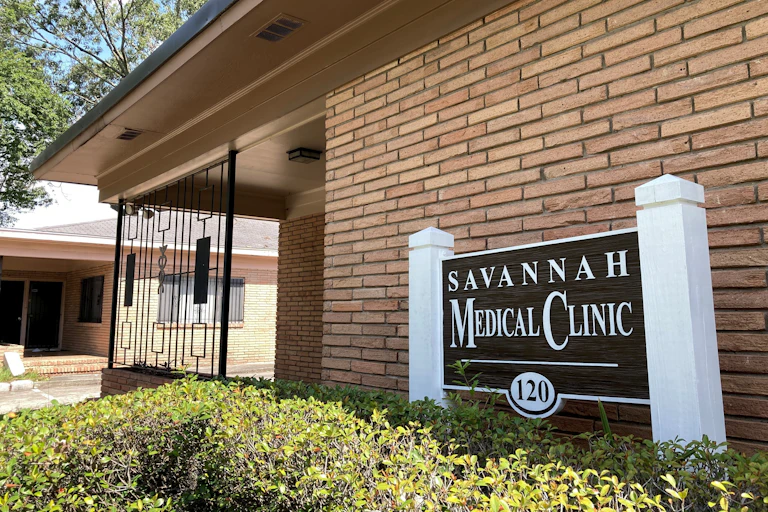 A brick building with a sign in front of it that says 'Savannah Medical Clinic.'