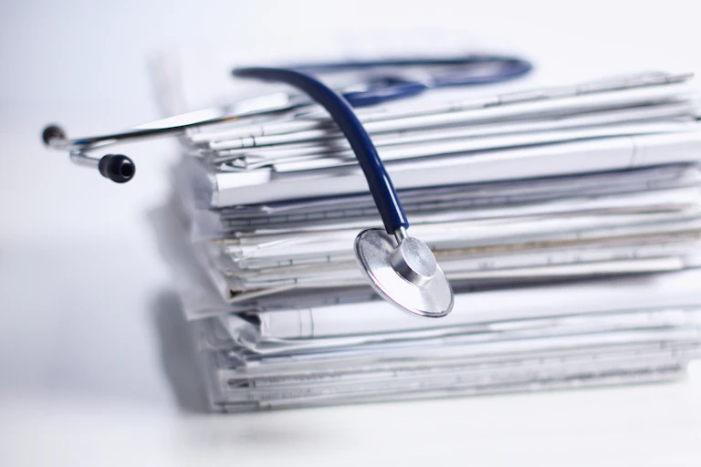 Pile of papers with a stethascope on top
