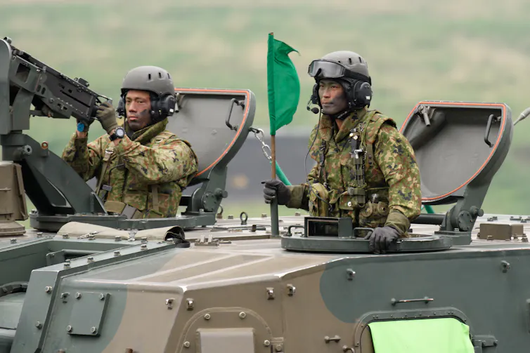 Japan's Ground Self-Defense Forces (JGSDF) soldiers ride a Type 99 155mm self-propelled howitzer, May 2021.