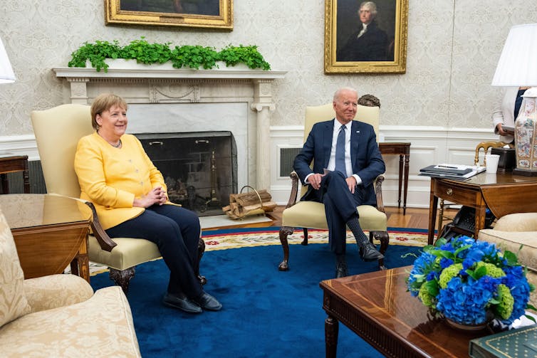 On the right a man in a suit and on the right a woman in yellow.