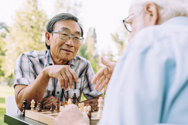 Two older men play chess