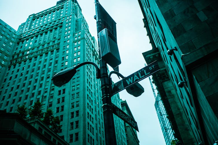 New York skyscraper above Wall Street sign.