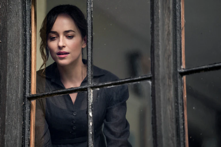 A woman looks out a window.