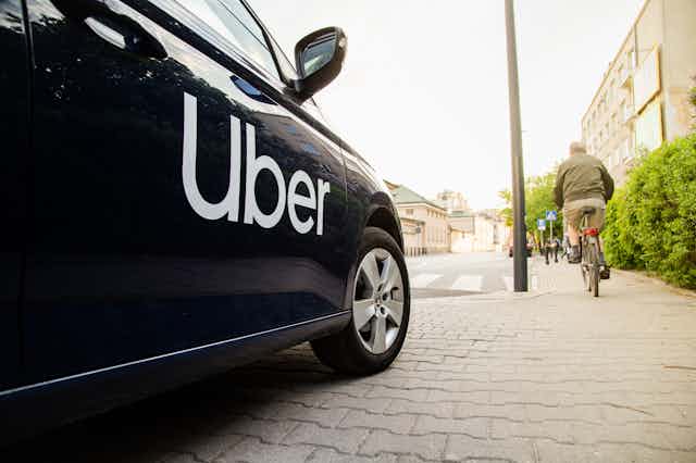 a close up of a black car with UBER printed in white writing