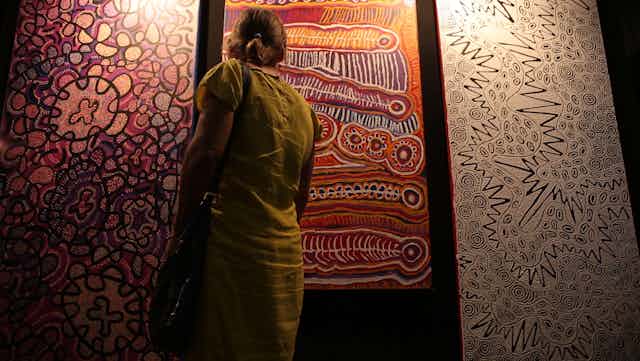 A woman looks at Indigenous art