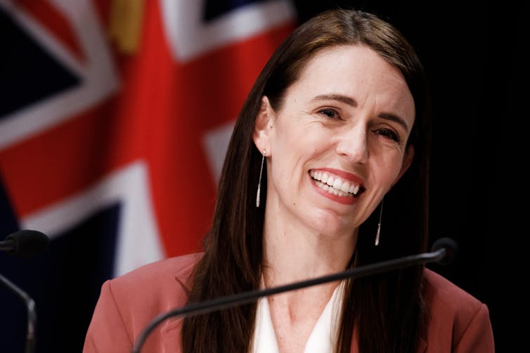 Jacinda Ardern speaks into a microphone.