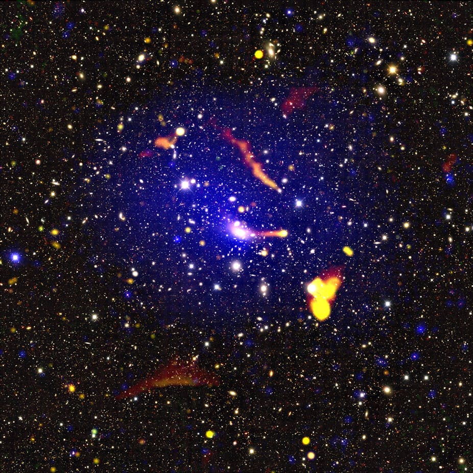 Colour-composite image of the merging galaxy cluster Abell 3266, using data from ASKAP and the ATCA (yellow, orange, and red colours), XMM-Newton (blue colours) and the Dark Energy Survey (background map). 