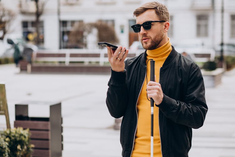 Image of a blind man talking on the phone.