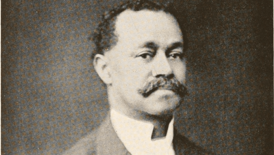 Black and white photograph of an African American man with a mustache and collared shirt.