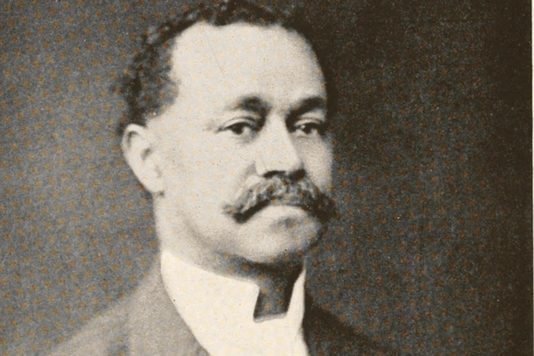 Black and white photograph of an African American man with a mustache and collared shirt.