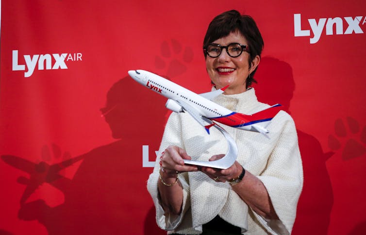 The CEO of Lynx Air holds up a model of one of the new airline's jets.