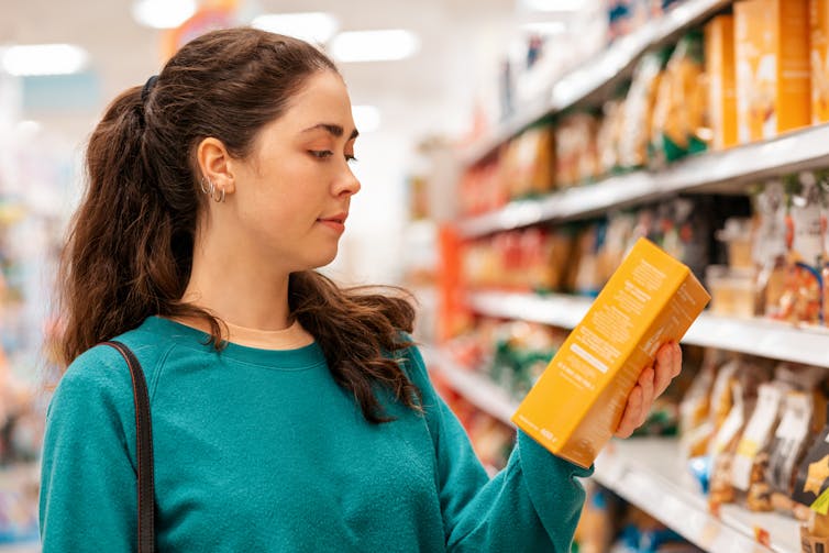 Woman reading the nutritional label of a grocery store product
