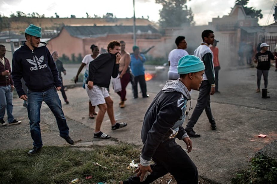Men walking and crouching low while protesting.