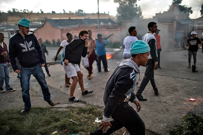 Men walking and crouching low while protesting.