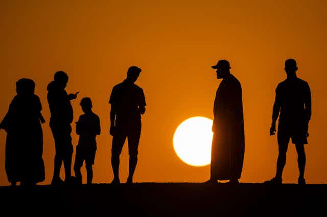 People silhouetted against sunset
