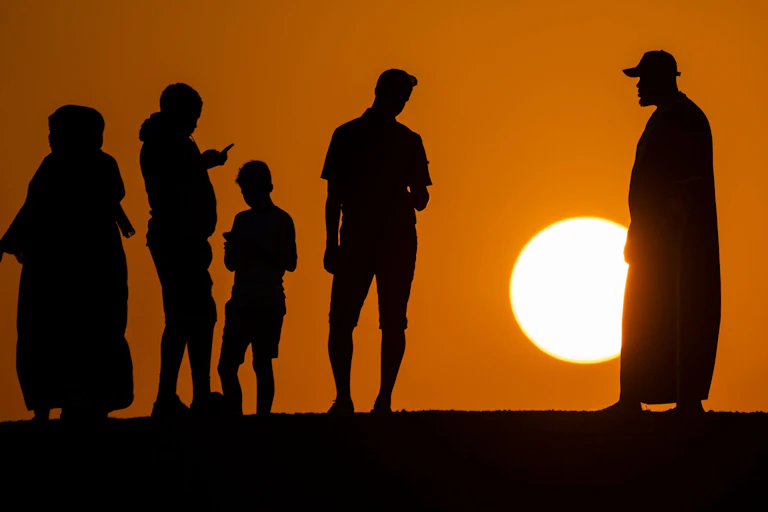 People silhouetted against sunset