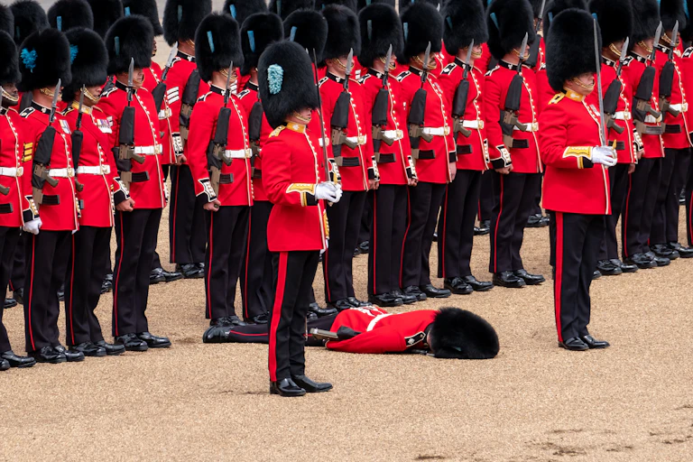 A row of Coldstream Guards with one who has fainted.