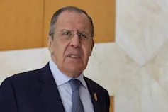 A balding man in glasses and a dark suit.