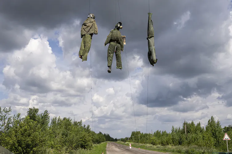 Dummies depicting Russian soldiers hang from wires.
