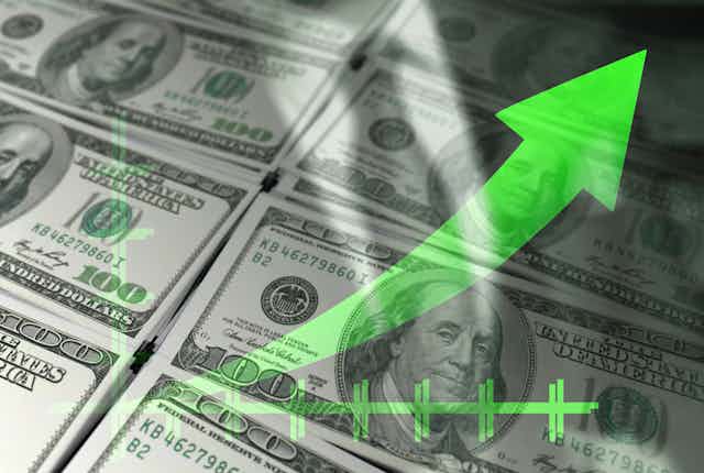 A graphic showing a green arrow going up, with one hundred dollar bills in the background