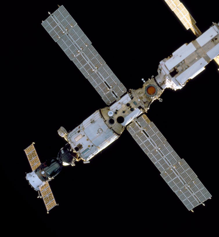 A photo of sections of the ISS showing large solar panels sticking out from a central column.