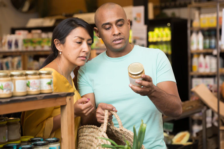Couple reading the small print on a jar.