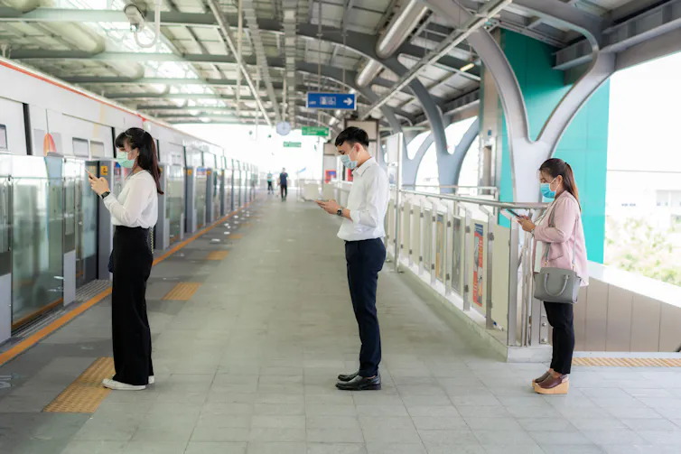 People in socially distanced queue for the train.