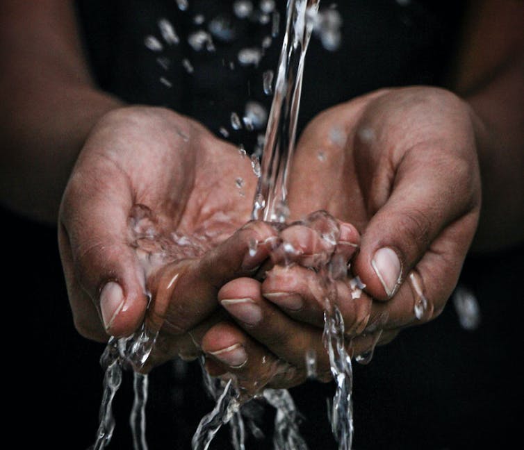 mains avec de l’eau qui coule