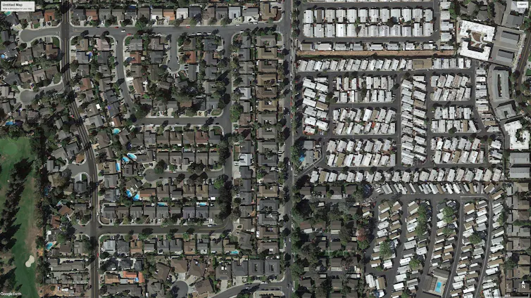 Aerial view of a suburban neighborhood and an adjoining manufactured housing park.