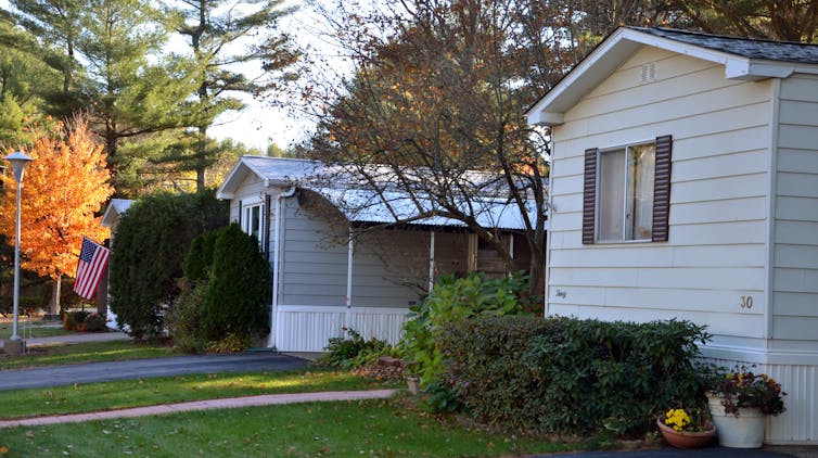 Manufactured homes facing a tree-lined street.