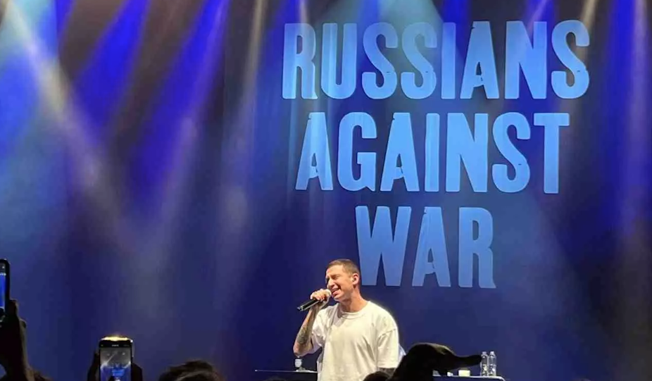 Le chanteur russe Oxxxymiron en concert. Derrière lui, l'inscription « Russians against war ». 