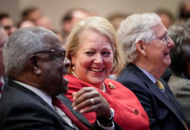 Clarence Thomas sits next to his wife Ginni Thomas, with Senator Mitch McConnell in the background 
