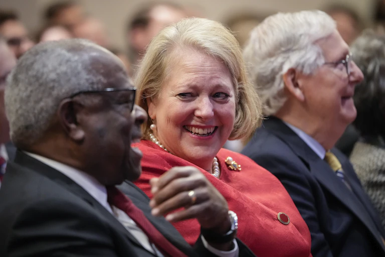 Clarence Thomas sits next to his wife Ginni Thomas, with Senator Mitch McConnell in the background